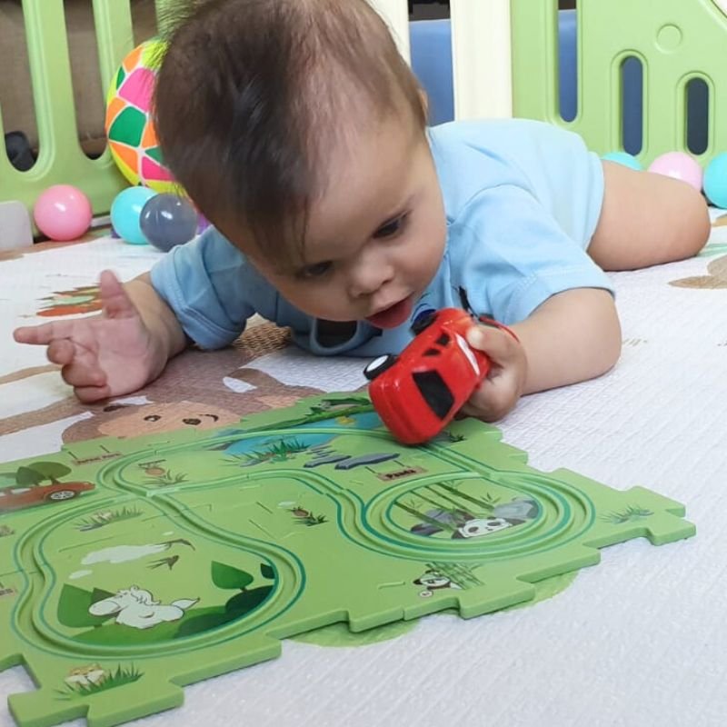 A joyful baby with Down syndrome playing with a colorful toy car, showcasing happiness and engagement in play.