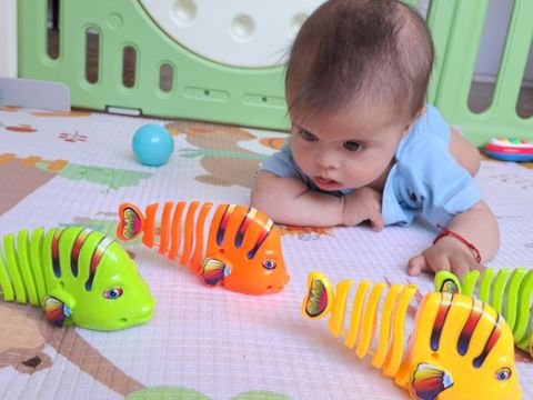A focused child with Down syndrome playing with toys, showcasing concentration and engagement in activities.